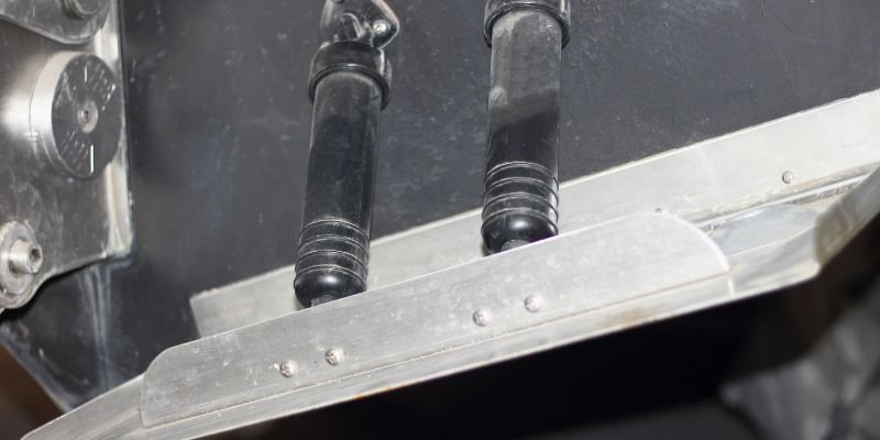 Close-up view of a boat's trim tabs on the transom, illustrating how they are used to adjust the vessel's angle and improve performance on the water.